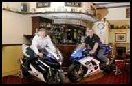 Peter and Peter in bar on race bikes